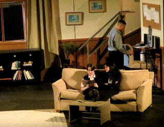 (Image: The Living Room Set with Two Actors on a Couch)