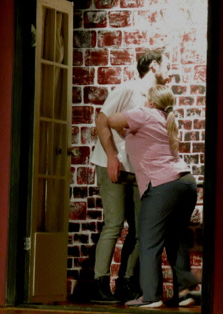 (Image: A Woman Pushes a Man Over an Unseen Balcony Railing