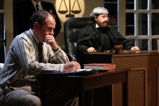 (Image: The Defence Lawyer mulls over a Document while
  the Judge Waits in the Background)