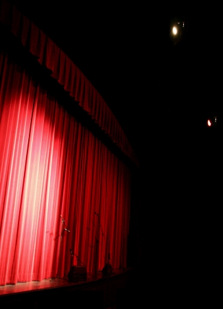 (Image Left: Stage Curtains Lit from Spotlights Overhead)